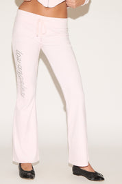 Light pink pants with embellishments on a white background