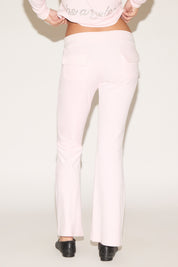 White pants worn by a person on a plain background