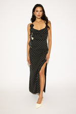 Woman wearing a black dress with white polka dots on a white background