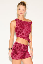 Woman wearing a red floral top and skirt set on a white background