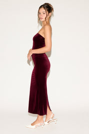 Woman wearing a burgundy strapless gown on a white background