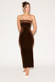 Woman wearing a brown strapless dress on a white background