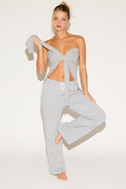 Woman wearing a gray lounge set on a white background