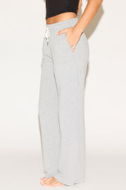 Person wearing gray sweatpants on a white background