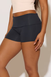 Person wearing black athletic shorts on a plain background