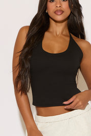 Woman wearing a black tank top against a white background