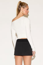 A woman in a white top and a black skirt.