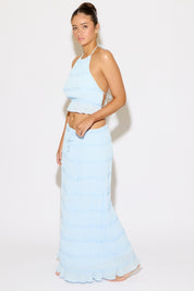 Woman wearing a light blue outfit on a white background