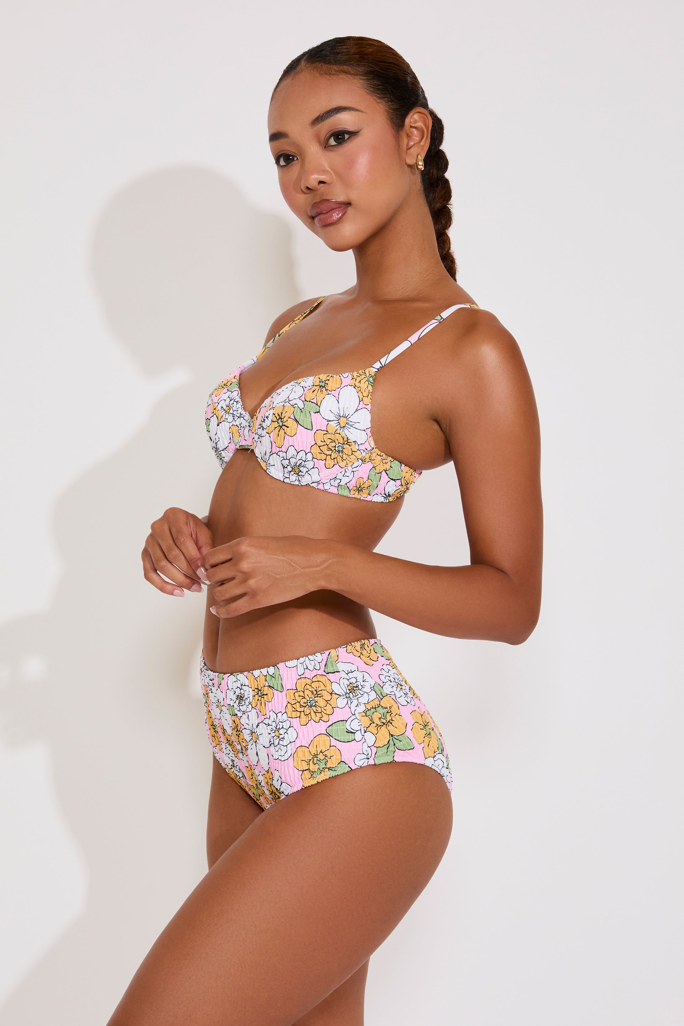 Woman wearing a floral bikini set against a white background