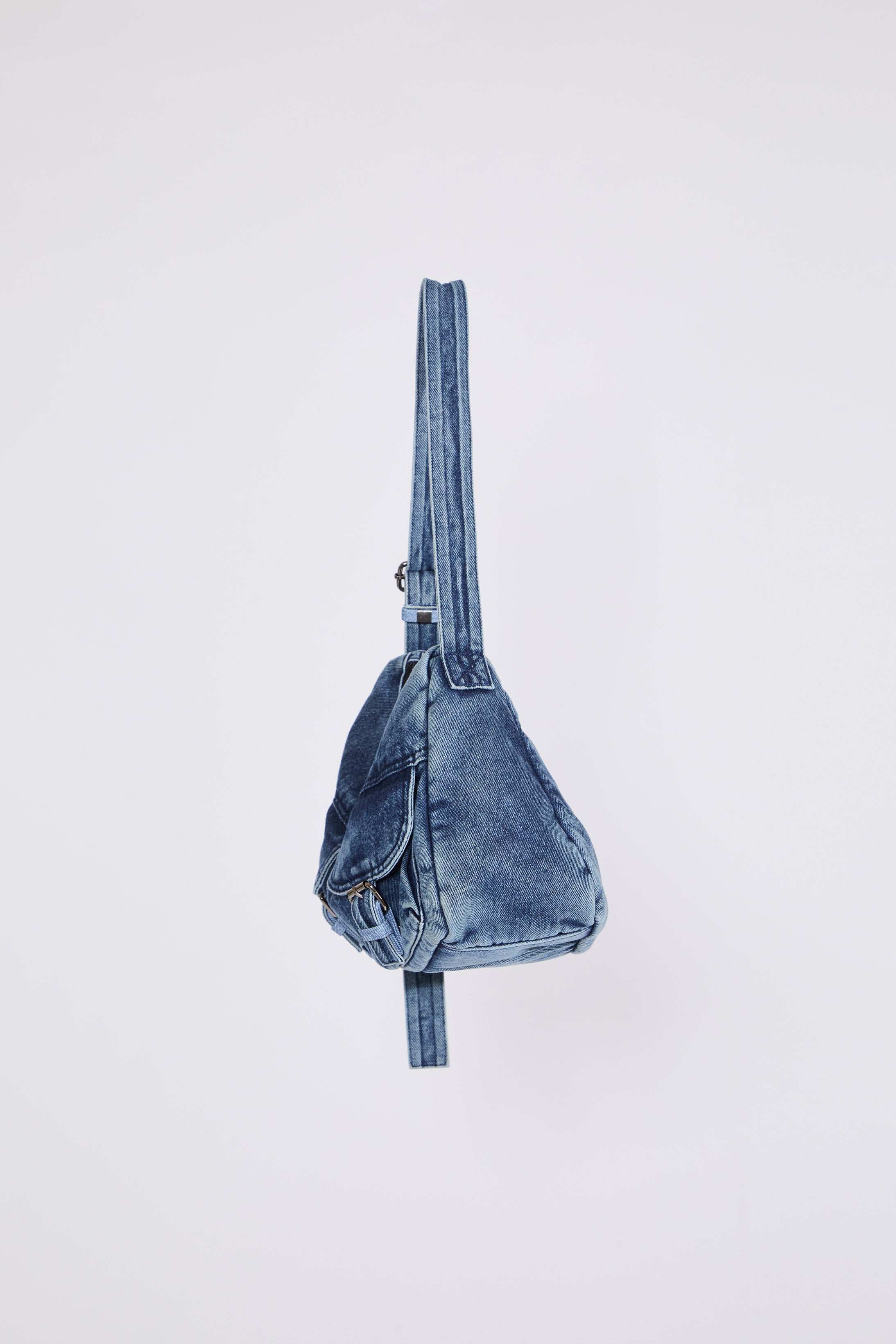 Blue denim crossbody bag on a light gray background