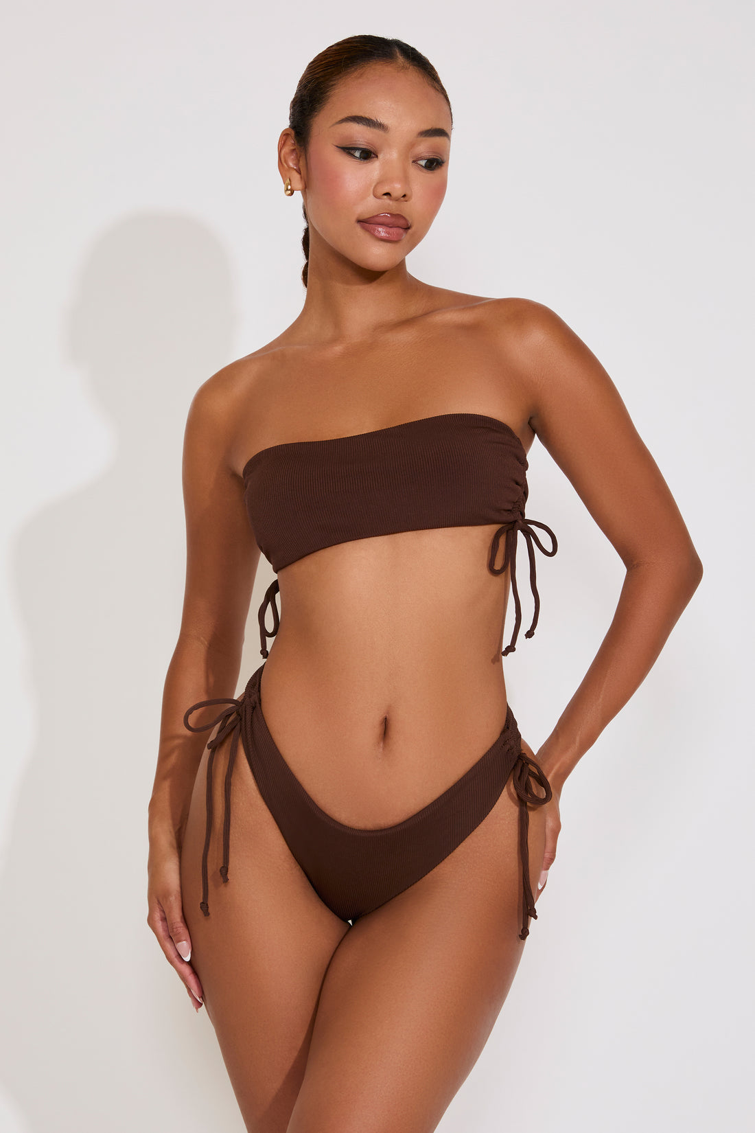 Woman wearing a brown bikini set on a white background