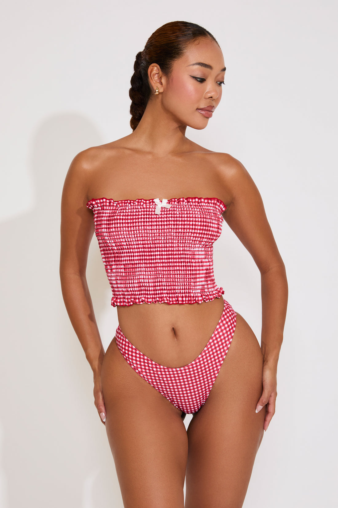 Woman wearing a red and white checkered bikini against a white background