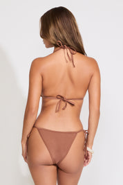 Model is wearing brown ocean charms lace trim string bikini set on a white background.