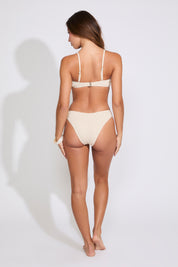 Model is wearing a peach SEASHELL DETAIL SMOCKED STRAPLESS BIKINI SET on a white background.