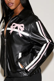 Black leather jacket with pink and white accents worn by a model against a plain background