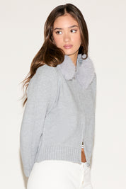 Woman wearing a gray knitted cardigan against a white background