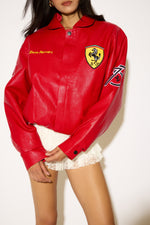 Red leather jacket with Ferrari logo worn by a person on a white background