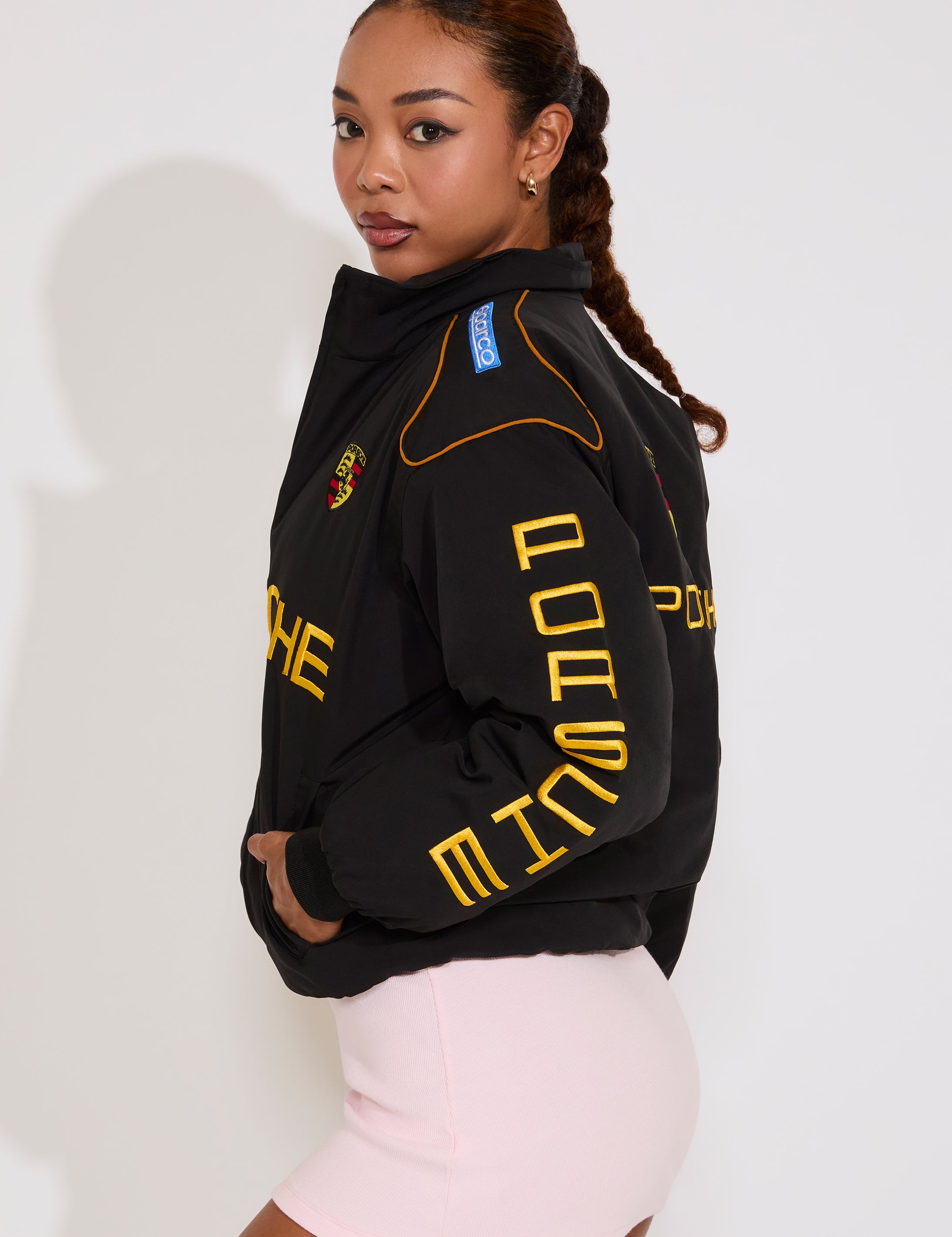 Woman wearing a black jacket with yellow text on a white background