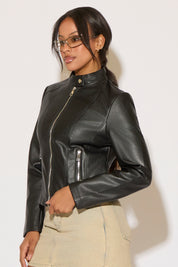 Woman wearing a black leather jacket and denim skirt on a white background