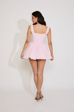 Woman wearing a pink checkered dress against a white background