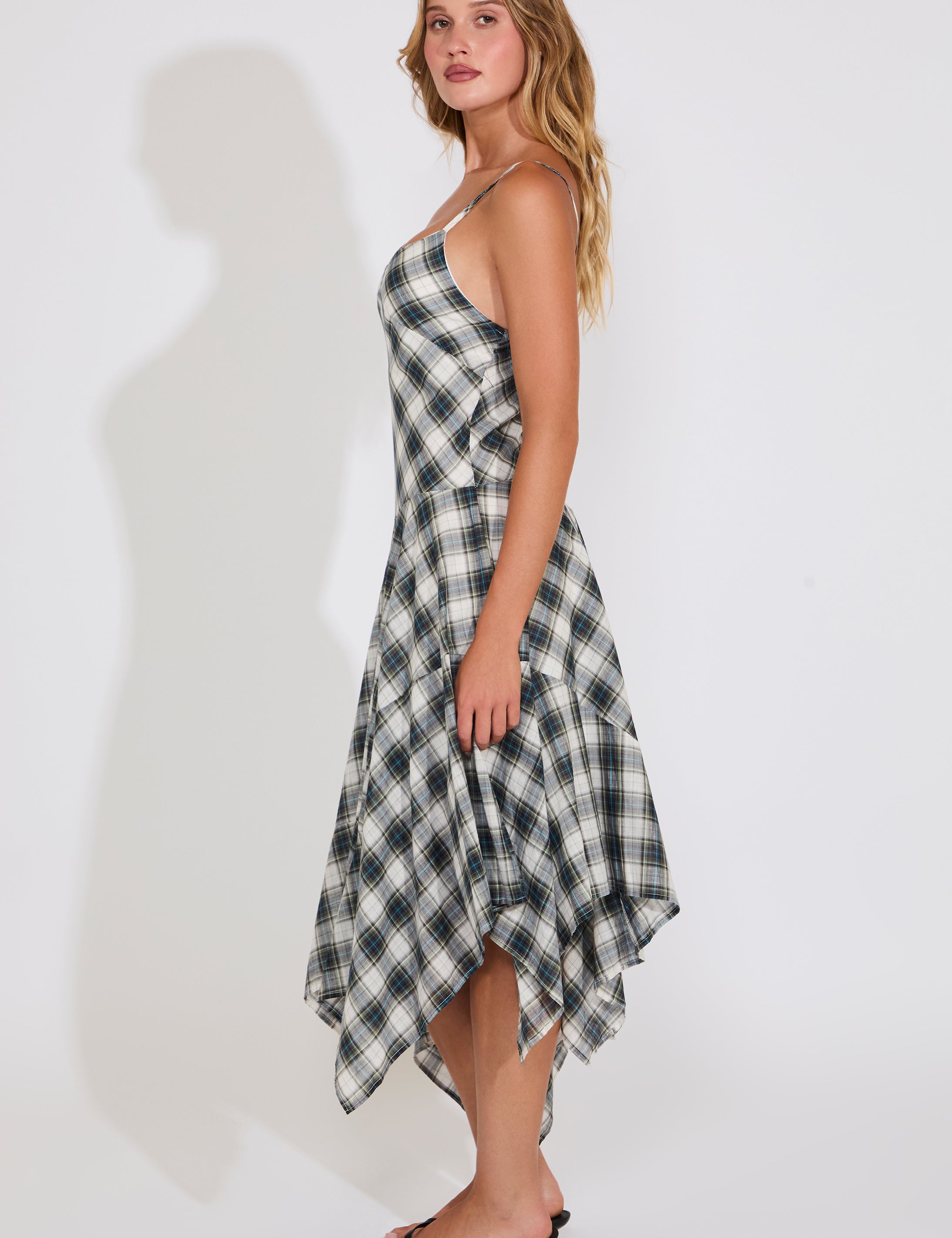 Woman wearing a plaid dress against a white background
