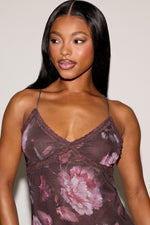 Woman wearing a floral lace top against a plain background