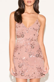 Pink sequin dress worn by a model on a white background