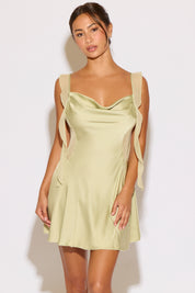 Woman wearing a light green dress against a white background
