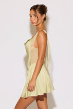 Woman wearing a light green dress against a white background