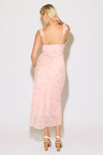Model is wearing a pink ruffle strap v neck floral column maxi dress on a white background. 