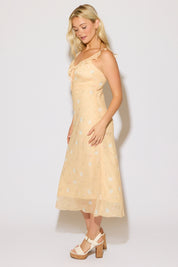 Model is wearing a yellow ruffle strap v neck floral column maxi dress on a white background. 