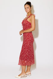 Woman wearing a red floral dress against a white background