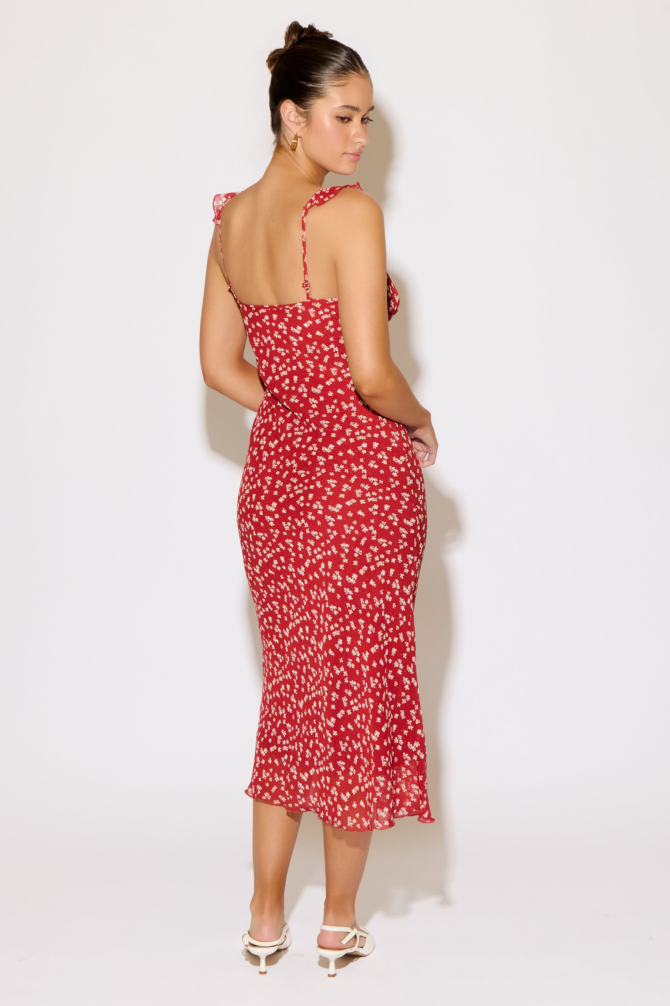 Woman wearing a red floral dress against a white background