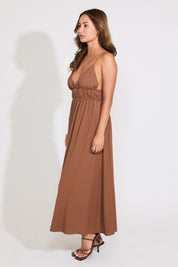 Model is wearing a brown sleeveless maxi dress on a white background.