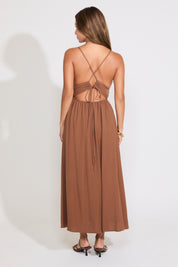 Model is wearing a brown sleeveless maxi dress on a white background.