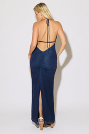 Model is wearing a blue tie neck and open back floral print overlay maxi dress on  a white background.