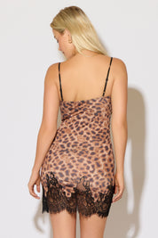 Model is wearing a lace bust and hem cami strap leopard print mini dress on a white background.