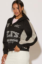 Woman wearing a black and gray hoodie on a white background