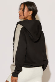 Woman wearing a black and gray hoodie on a white background