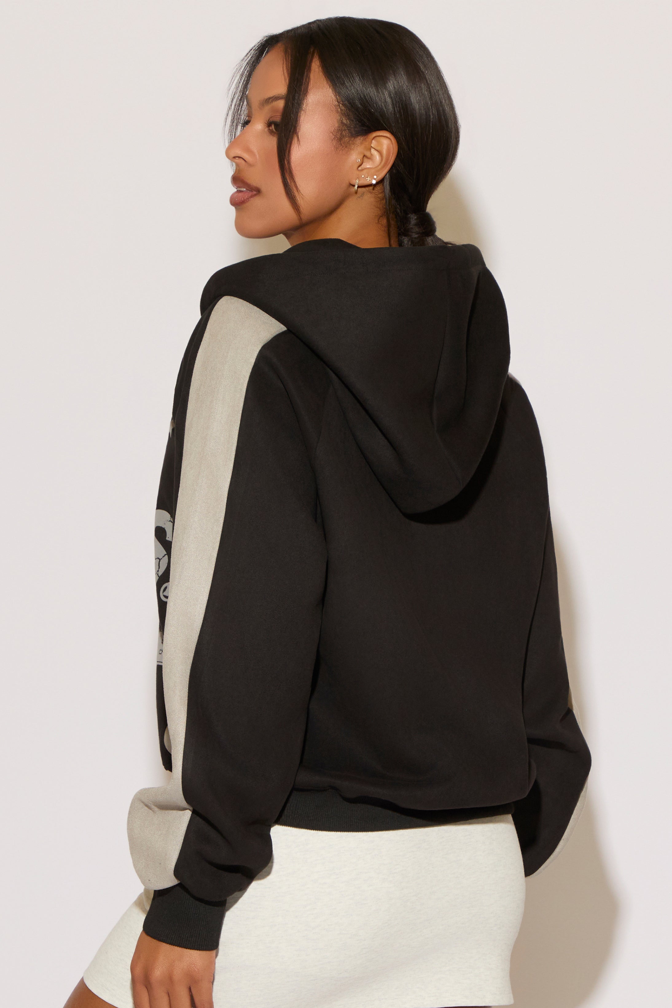 Woman wearing a black and gray hoodie on a white background