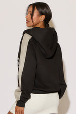 Woman wearing a black and gray hoodie on a white background