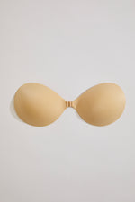 Beige strapless bra on a light gray background