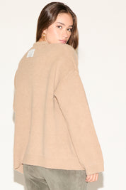 Woman wearing a beige cardigan on a white background