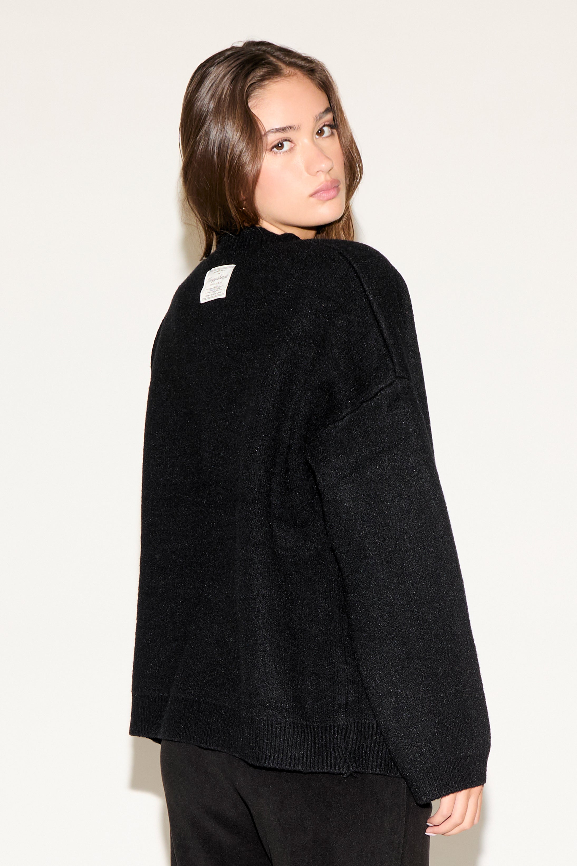 Woman wearing a black sweater against a white background