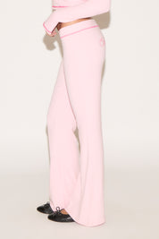Person wearing a pink outfit with wide-leg pants on a light background