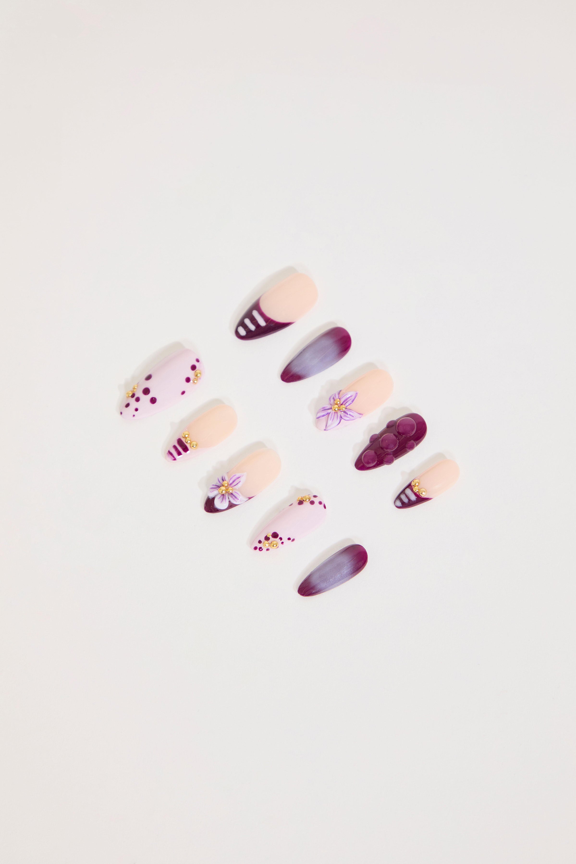 Set of decorative false nails with floral designs on a light background