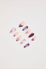 Set of decorative false nails with floral designs on a light background