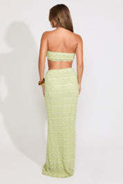 Model is wearing a green textured shell detail bralette top and maxi skirt set on a white background.