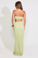 Model is wearing a green textured shell detail bralette top and maxi skirt set on a white background.