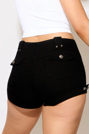 Black shorts with silver buttons worn by a person on a plain background